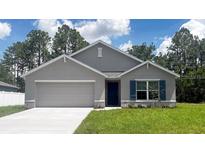 Charming single-story home with blue shutters, a two-car garage, and a well-manicured lawn at 553 Marion Oaks Mnr, Ocala, FL 34473