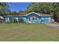 Charming turquoise home featuring a well-maintained lawn, mature trees, and a cozy, inviting front yard at 731 Cloverleaf Blvd, Deltona, FL 32725
