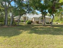 Charming single-story home nestled among mature trees, with a lush green lawn and inviting curb appeal at 9915 Sw 47Th Ave, Ocala, FL 34476