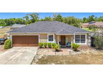 Charming single-story home featuring a well-manicured lawn and a welcoming front porch at 14978 Sw 46Th Cir, Ocala, FL 34473