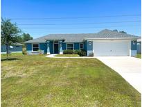 Charming one-story home with a well-manicured lawn, attached garage, and a freshly painted exterior at 15317 Sw 65Th Terrace Rd, Ocala, FL 34473