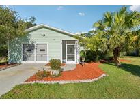 Charming single-story home with a well-manicured lawn, mature landscaping, and a cozy screened-in porch at 28 Gordon Ct, Leesburg, FL 34788