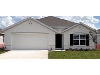 Charming single-story home featuring a white stucco exterior, attached garage, and a well-manicured lawn at 4714 Sw 88Th Ln, Ocala, FL 34476