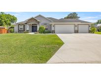 Charming single-story home with well-manicured lawn, stone accents, and a three-car garage at 5144 Ne 9Th St, Ocala, FL 34470