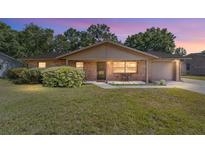 Charming brick home featuring a well-maintained lawn and inviting front porch at 5720 Se 22Nd Pl, Ocala, FL 34480