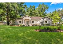 Charming single-story home with a manicured front lawn and mature trees in a peaceful setting at 8630 Sw 20Th Ct, Ocala, FL 34476