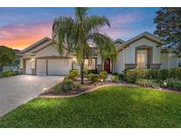 Beautifully landscaped front yard with a charming home featuring a well-maintained lawn and a welcoming red front door at 9443 Sw 71St Loop, Ocala, FL 34481