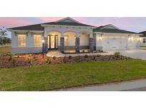 Charming single-story home showcasing stone-accented columns and well-manicured front yard at 9973 Sw 107Th Ter, Ocala, FL 34481