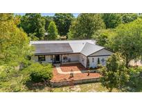 Beautiful home featuring solar panels, a metal roof, and meticulously landscaped grounds, blending comfort and efficiency at 18695 Ne 5Th Terrace Rd, Citra, FL 32113