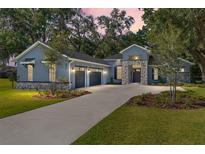 Charming home featuring a manicured lawn, stone accents, a two-car garage, and a welcoming front entrance at 2515 Se 77Th St, Ocala, FL 34480