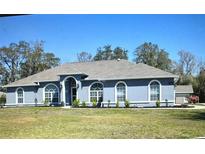 Charming single-story home featuring a well-manicured lawn, arched windows, and neutral exterior paint at 5281 Sw 33Rd St, Ocala, FL 34474