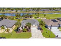 Beautiful home with a paver driveway, lush landscaping and picturesque views of the lake and golf course at 7503 Sw 97Th Terrace Rd, Ocala, FL 34481