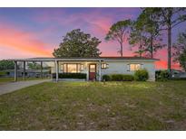 Charming single-story home featuring a covered carport and a well-maintained front yard at 10040 Sw 93Rd Ct, Ocala, FL 34481
