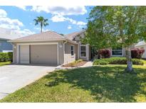 Inviting front yard with lush lawn and well-maintained landscaping showcasing the charming exterior of this single-story home at 11133 Sw 73Rd Ter, Ocala, FL 34476