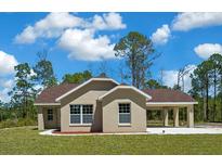 Charming one-story home features a welcoming covered carport, well-manicured lawn and neutral color palette at 13491 E Hwy 316, Fort Mc Coy, FL 32134