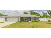 Charming single-story home boasts a well-manicured front yard and an attached two-car garage at 1453 Ne 161St Pl, Citra, FL 32113