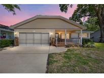 Charming single-story home showcasing a covered front porch, and a two-car garage at 8831 Sw 94Th Ln # H, Ocala, FL 34481