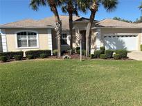 Beautiful single-story home featuring lush landscaping, a well-manicured lawn, and a two-car garage at 9288 Sw 93Rd Cir, Ocala, FL 34481