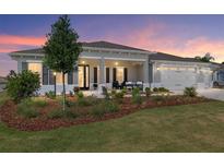 Beautiful single-story home with a welcoming front porch and well-manicured lawn at sunset at 9764 Sw 81St Ln, Ocala, FL 34481