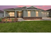 Charming single-story home features a stone accent base, well-maintained lawn, and welcoming walkway at 9945 Sw 83Rd Ln, Ocala, FL 34481