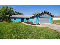 Charming single-story home with a vibrant blue exterior, complemented by a well-manicured lawn at 5220 Sw 161St Place Rd, Ocala, FL 34473