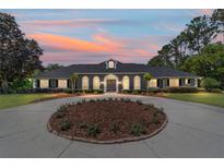 Charming home with a circular driveway highlighted by a colorful sunset at 5484 Sw 30Th Ave, Ocala, FL 34471