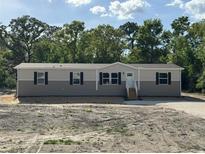 Charming single story home featuring horizontal siding, black shutters, and a front entrance with stairs at 6658 Sw 165Th Ct, Ocala, FL 34481