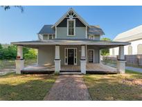 Charming two-story home featuring a full front porch with sturdy support columns and a classic brick pathway at 721 Ne 2Nd St, Ocala, FL 34470