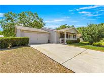Charming single-story home features a covered porch, two-car garage, and well-maintained landscaping at 10989 Sw 86Th Ave, Ocala, FL 34481