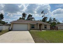 Charming single-story home featuring a two-car garage, well-maintained lawn, and neutral exterior paint at 15976 Sw 23Rd Court Rd, Ocala, FL 34473