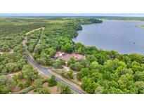 Stunning aerial view of the home and lake, surrounded by lush greenery at 16891 Ne 243Rd Place Rd, Fort Mc Coy, FL 32134