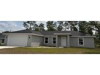 Charming single-story home with a gray exterior, well-manicured lawn, and an attached garage at 14573 Sw 25Th Ter, Ocala, FL 34473