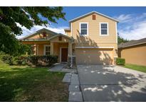 Charming two-story home with a well-manicured lawn and attached two-car garage at 5128 Grassy Knoll Dr, Tavares, FL 32778