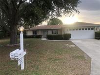 Charming single-story home with a two car garage and a well-manicured front yard and garden at 9896 Sw 61St Ct, Ocala, FL 34476