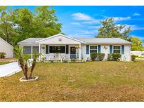 Charming single-story home with a welcoming front porch and well-maintained lawn at 10824 Sw 90Th Ter, Ocala, FL 34481
