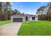 Charming single-story home featuring a well-manicured lawn and a two-car garage with stone accents at 15769 Sw 37Th Cir, Ocala, FL 34473
