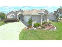 Charming single-story home featuring a well-manicured lawn, inviting entrance, and attached two-car garage at 2323 Nw 55Th Avenue Rd, Ocala, FL 34482