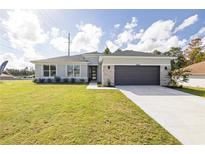 Beautiful single-story home with a two-car garage, stone accents and a well manicured lawn at 2647 Sw 178 St, Ocala, FL 34473