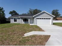 Charming single-story home features a gray exterior, white trim, and a spacious two-car garage at 28 Olive Dr, Ocala, FL 34472