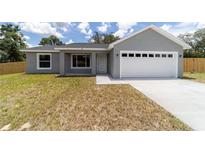 Charming single-story home featuring a two-car garage and a well-maintained lawn at 28 Olive Dr, Ocala, FL 34472