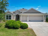 Charming single-story home with a well-manicured lawn and a three-car garage at 779 Oldsmar Ter, The Villages, FL 32163