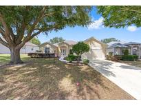 Charming single story home boasts a manicured lawn, lovely landscaping, and a concrete driveway at 9693 Sw 90Th St, Ocala, FL 34481