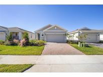Charming single-story home features a manicured lawn, brick driveway, and attached two-car garage at 5430 Nw 46Th Lane Rd, Ocala, FL 34482