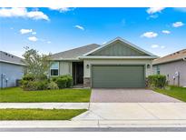 Charming one-story home featuring a two-car garage, brick-paved driveway, and beautifully landscaped front yard at 5616 Nw 39Th Ln, Ocala, FL 34482