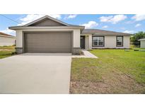 Charming one-story home featuring a two-car garage, lush lawn, and neutral exterior at 60 Walnut Dr, Ocala, FL 34480