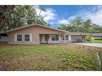 Charming single-story home with a well-manicured lawn, covered porch, and attached carport at 660 Silver Pass, Ocala, FL 34472