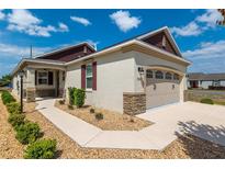 Charming home featuring stone accents, desert landscaping, and attached two car garage at 9923 Sw 98Th Ln, Ocala, FL 34481