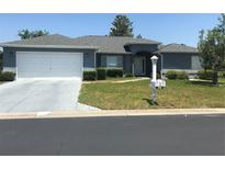 Charming single-story home with well-maintained lawn, gray roof and a two-car garage at 11411 Sw 138Th Ln, Dunnellon, FL 34432