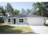 Charming single-story home featuring a well-maintained lawn and a two-car garage at 18 Larch Radl, Ocala, FL 34480