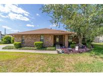 Charming brick home with well-manicured lawn, bushes, and a beautiful tree in the front yard on a sunny day at 2045 Se 32Nd St, Ocala, FL 34471
